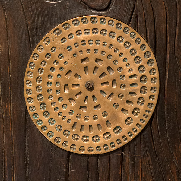 Round die plate mounted on wooden board from collection of Dr